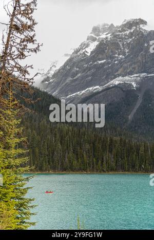 Superbes scènes de la nature à Emerald Lake, parc national Yoho pendant l'été avec canot rouge en vue sur l'eau turquoise, énorme sommet de montagne et boréal Banque D'Images