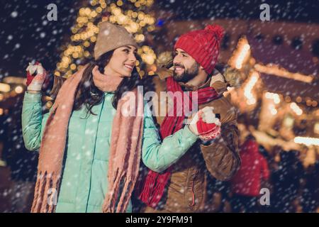 Photo des amoureux mignans mignon danse porter chapeau veste foulard gants près de l'arbre sur le nouvel an salon extérieur Banque D'Images