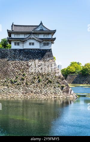 Vue avec la tourelle Inui-yagura dans le château d'Osaka, Japon. Les douves extérieures du mur de pierre massif du château d'Osaka Banque D'Images