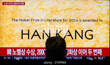 Séoul, Corée du Sud. 10 octobre 2024. Une émission de télévision Yonhapnews de 24 heures à la gare ferroviaire de Séoul montrant une émission d'informations avec des inscriptions du lauréat du prix Nobel de littérature 2024, l'auteur sud-coréen Han Kang. L'auteure Han Kang est devenue la première coréenne à remporter le prix Nobel de littérature, pour son travail mettant en vedette une harmonie entre la souffrance mentale et physique, et des événements historiques. Crédit : SOPA images Limited/Alamy Live News Banque D'Images