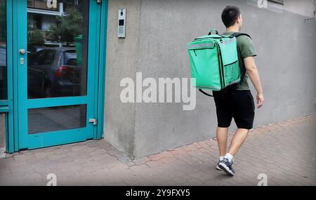 Transporteur de livraison de nourriture va pour remplir une commande. Courrier avec un sac à dos de livraison de nourriture. Banque D'Images