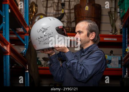 Le commissaire-priseur Shane Oliver détient le lot 2387 ; le casque de course Stig's BBC Top Gear signé par Stig & Jeremy Clarkson aux enchères. Ce casque controversé est probablement celui signé par le producteur irlandais Oisin Tymon avec qui Clarkson a eu une atercation en 2015. Signé par Clarkson' -F..k Off et The Stig -to the main Man Osh!! Restez Speedy Brother avec James May. On pensait qu'il était laissé dans les bureaux de Top Gear lorsque le studio a été abandonné après l'altercation puis l'abandon de la série. Eastbourne Auction House, East Sussex, Royaume-Uni 10 octobre 2024 Banque D'Images