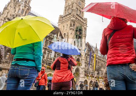 Touristen lauschen unter Regenschirmen dem Glockenspiel im Rathausturm, München, 10. Oktober 2024 Deutschland, München, 10. Oktober 2024, Touristen lauschen im Regen dem Glockenspiel im Rathausturm, stehen unter Regenschirmen beim Sightseeing auf dem Marienplatz, Donnerstagnachmittag um 17 Uhr, bayerisch, Regenschauer, Regenwetter, Wetter, regnerisch, Bayern, *** les touristes écoutent le carillon dans la tour de la mairie sous parapluies, Munich, 10 octobre 2024 Allemagne, Munich, le 10 octobre 2024, les touristes écoutent le carillon dans la tour de la mairie sous la pluie, debout sous des parapluies pendant que sig Banque D'Images