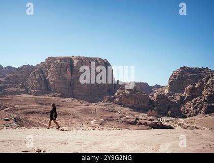 Wadi Musa, Jordanie - 20 novembre 2023 : femme touriste marchant sur un chemin avec l'ancienne ville de Petra en arrière-plan. Banque D'Images