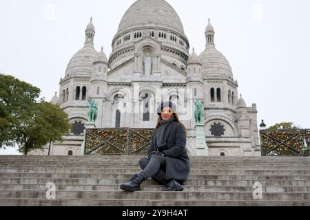 Jeune femme en randonnée hivernale au Sacré coeur, monument emblématique de Montmartres Banque D'Images