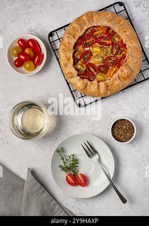 Photographie culinaire de galette avec tomates et ricotta ; vin blanc, assaisonnement, farine de blé entier ; pâtisserie salée, pâte brisée Banque D'Images