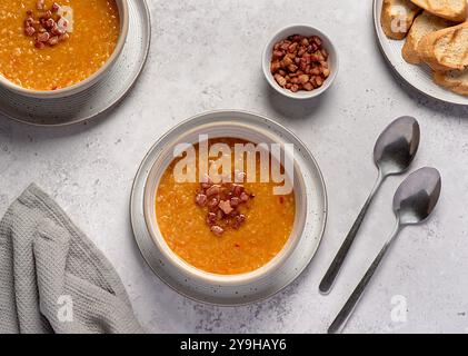 Photographie culinaire de soupe de lentilles rouges avec Chili et bacon, carotte, oignon, ail, pain grillé, bouillon, bouillon, set table Banque D'Images