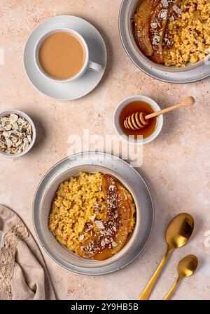 Photographie alimentaire de bouillie de millet avec banane caramélisée, noix de pécan, noix, flocons de noix de coco, chia, graines de lin, miel, thé au lait d'amande Banque D'Images