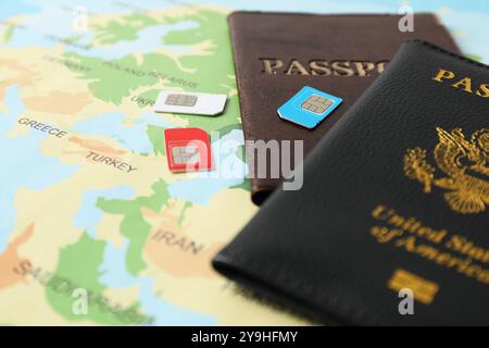 Cartes SIM et passeports sur la carte du monde, gros plan Banque D'Images