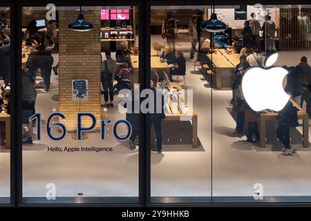 Apple Store avec des clients explorant les produits et écrans les plus récents. Ambiance mettant en valeur une expérience de vente au détail moderne et l'engagement des clients. Banque D'Images