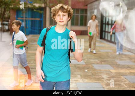 Un jeune garçon rentre à la maison après les cours scolaires Banque D'Images