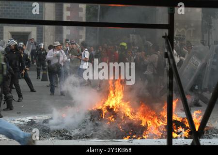 Des manifestants ont déclenché un incendie lors de la manifestation des 43 enseignants disparus d'Ayotzinapa et de la police qui tentait de contrôler la situation. Banque D'Images