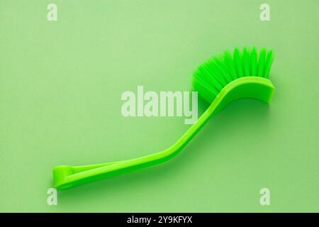 Brosse en plastique avec poils verts pour le nettoyage de la maison. Banque D'Images