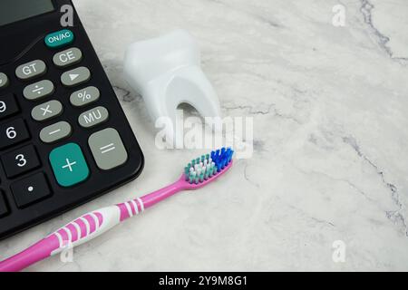 Brosse à dents et dent avec calculatrice vue de dessus sur fond de marbre, argent dentaire et coûts de traitement dentiste Banque D'Images