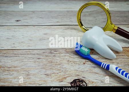 Concept d'hygiène dentaire de brosse à dents avec loupe sur fond en bois Banque D'Images