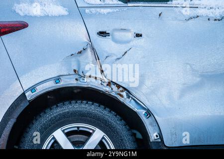 Aile arrière cassée et porte d'une voiture grise Banque D'Images