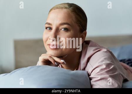 Une jeune femme belle taille repose sur des oreillers à la maison, exsudant chaleur et confiance. Banque D'Images