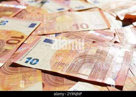 Sunlight 10 (dix) billets d'euros couchés à la surface. Papier-monnaie préparé pour payer les factures et autres petites dépenses en espèces dans un pays de l'Union européenne. Banque D'Images