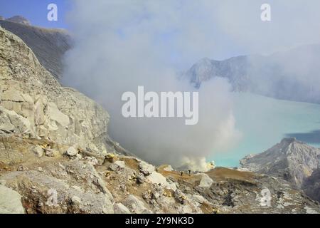 Les parois de caldeira du cratère Ijen avec son lac turquoise indiquent les niveaux élevés de soufre dans l’eau. Banque D'Images