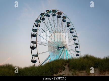 Egmond aan Zee, pays-Bas, 5 septembre 2024 - Grande roue illuminée sur la plage avec dune de sable de la ville en Hollande du Nord Banque D'Images