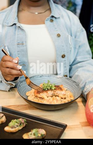 Femme assise à une table avec de la nourriture Banque D'Images
