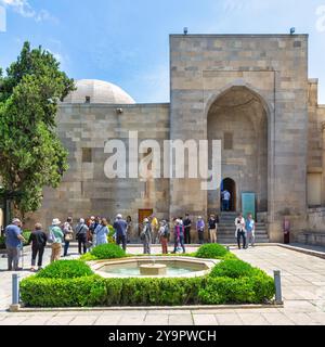 Bakou, Azerbaïdjan - 10 mai 2024 : les visiteurs se rassemblent dans la cour du Palais des Chirvanshahs, appréciant sa beauté architecturale et sa riche signification historique Banque D'Images