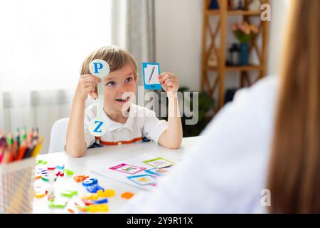 Garçon apprenant des lettres en salle de classe Banque D'Images