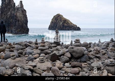 Pierres empilées sur la plage Ilhéus da Janela avec des formations rocheuses imposantes et des vagues océaniques en arrière-plan Banque D'Images