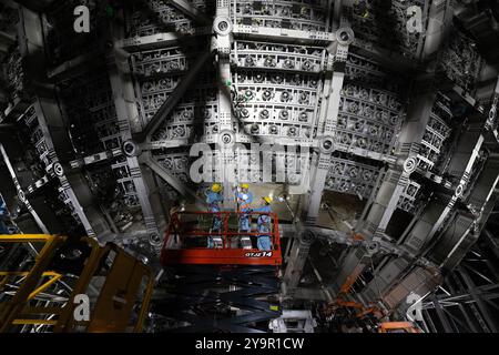 (241011) -- JIANGMEN, 11 octobre 2024 (Xinhua) -- des membres du personnel installent des tubes photomultiplicateurs du détecteur central de l'Observatoire souterrain de neutrinos de Jiangmen (JUNO) à Jiangmen, dans la province du Guangdong du sud de la Chine, 10 octobre 2024. La Chine a construit le plus grand détecteur sphérique transparent du monde à 700 mètres sous terre pour capturer des neutrinos insaisissables, souvent surnommés « particules fantômes », afin de percer les secrets de l'infiniment petit et de l'infiniment vaste de l'univers. La sphère acrylique de 12 étages avec un diamètre de 35,4 mètres, enfouie profondément dans une couche de granit d'une colline à Kai Banque D'Images