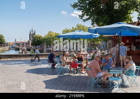 Les gens apprécient le beau temps sur la terrasse le long du port dans la ville historique de Zierikzee. Banque D'Images