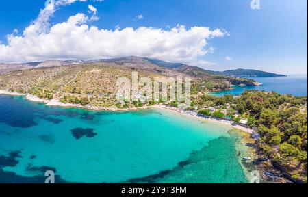 Vue aérienne de la plage d'Aliki à Thassos, en Grèce, avec des eaux turquoises, des collines couvertes de pins et un cadre méditerranéen tranquille parfait pour un pois Banque D'Images