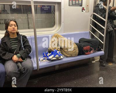 Homme sans-abri endormi dans le métro à New York le samedi 28 septembre 2024. (© Frances M. Roberts) Banque D'Images