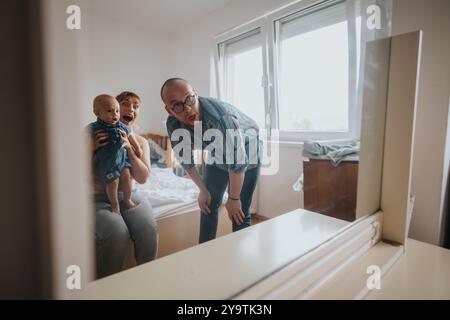 Famille joyeuse avec bébé posant ensemble dans une chambre lumineuse Banque D'Images
