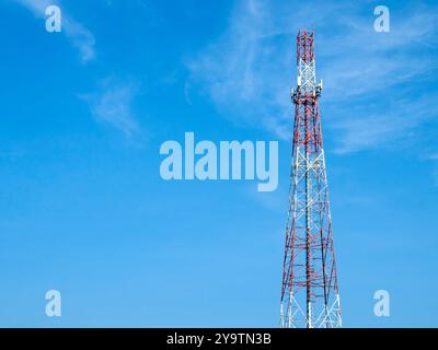 Une tour de télécommunications avec diverses formes d'antennes installées sur son corps, pilier de tour d'antenne haute de communication cellulaire sur le ciel bleu b Banque D'Images