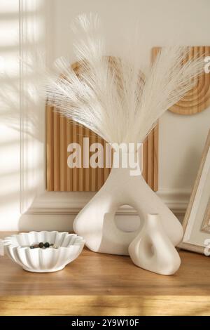 Belles plantes décoratives, vases et bol en céramique sur la table en bois à l'intérieur Banque D'Images