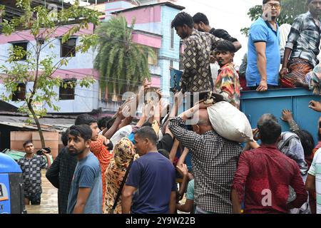 Les populations touchées par les inondations reçoivent des secours dans le district de Feni, au Bangladesh, le 25 août 2024. Banque D'Images