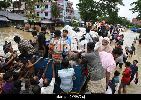 Les populations touchées par les inondations reçoivent des secours dans le district de Feni, au Bangladesh, le 25 août 2024. Banque D'Images