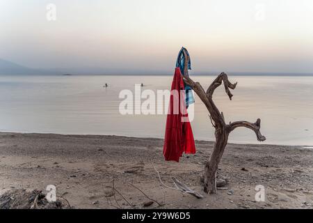 Travailleurs de l'industrie des mines de sel lavant et nageant dans le lac afrera au coucher du soleil, dépression de Danakil, région d'Afar, Ethiopie Banque D'Images