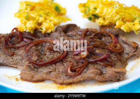 De la vraie nourriture, forte, riche en protéines et saine. Steak de croupe avec oignons, boulettes de riz et légumes Banque D'Images