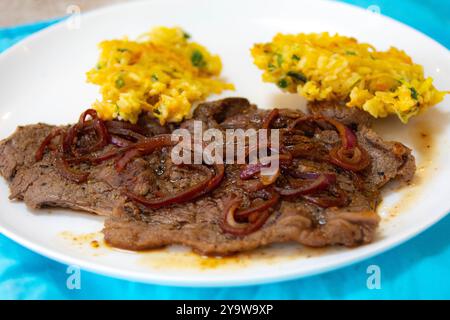 De la vraie nourriture, forte, riche en protéines et saine. Steak de croupe avec oignons, boulettes de riz et légumes Banque D'Images