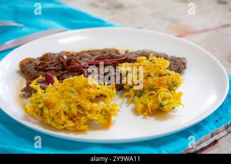 De la vraie nourriture, forte, riche en protéines et saine. Steak de croupe avec oignons, boulettes de riz et légumes Banque D'Images