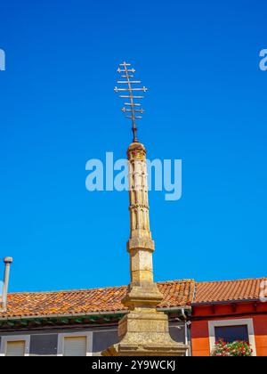 Une grande croix en pierre finement sculptée avec un sommet à plusieurs bras distinctif se dresse contre un ciel bleu vif. Banque D'Images