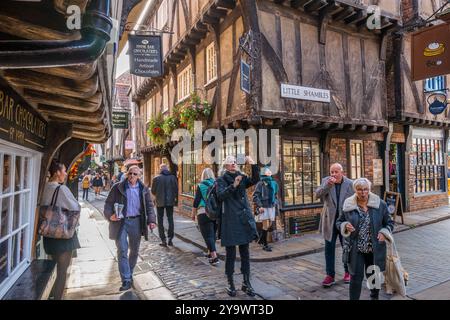 Les amateurs de shopping et les touristes négocient les rues étroites et les ruelles de la ville aciente de York, Yorkshire, Angleterre. Banque D'Images