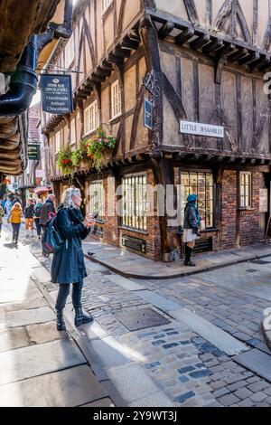 Les amateurs de shopping et les touristes négocient les rues étroites et les ruelles de la ville aciente de York, Yorkshire, Angleterre. Banque D'Images