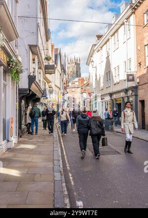 Les amateurs de shopping et les touristes négocient les rues étroites et les ruelles de la ville aciente de York, Yorkshire, Angleterre. Banque D'Images