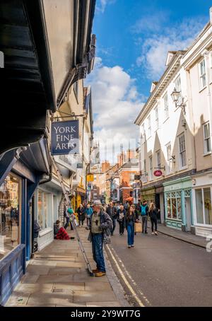 Les amateurs de shopping et les touristes négocient les rues étroites et les ruelles de la ville aciente de York, Yorkshire, Angleterre. Banque D'Images