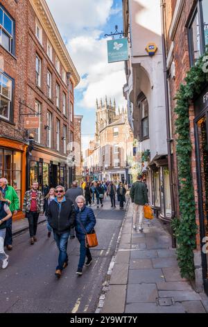 Les amateurs de shopping et les touristes négocient les rues étroites et les ruelles de la ville aciente de York, Yorkshire, Angleterre. Banque D'Images