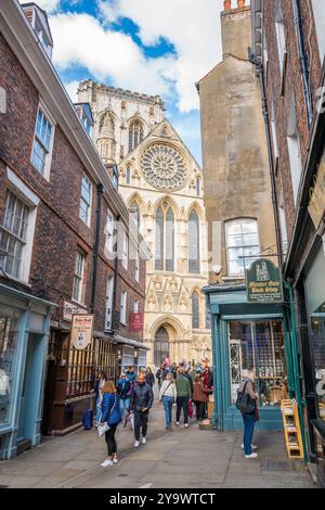 Les amateurs de shopping et les touristes négocient les rues étroites et les ruelles de la ville aciente de York, Yorkshire, Angleterre. Banque D'Images