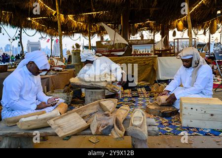 Doha, Qatar - 29 novembre 2023 : un homme arabe répare un filet de pêche pendant le festival des roulements à voile dans le village de Katara. Banque D'Images