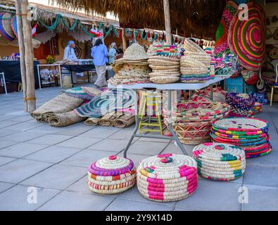 Doha, Qatar - 29 novembre 2023 : un homme arabe répare un filet de pêche pendant le festival des roulements à voile dans le village de Katara. Banque D'Images